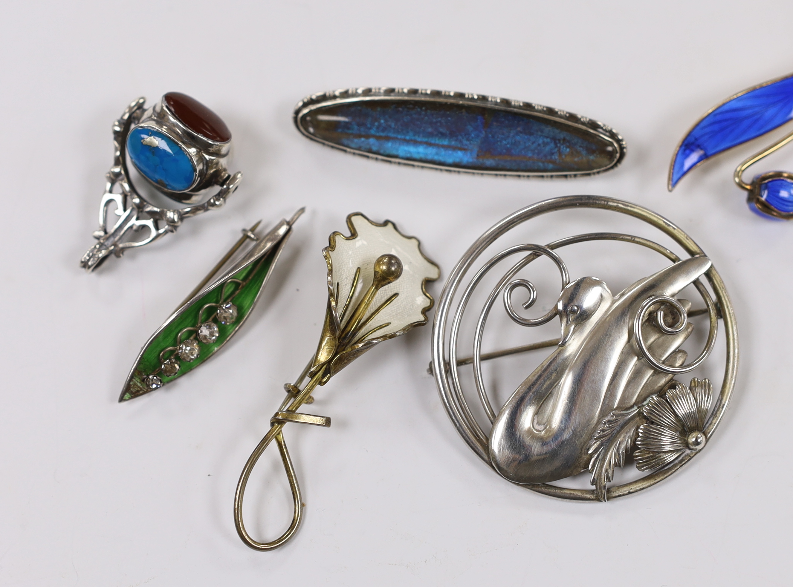 Two Norwegian sterling and enamel foliate spray brooches, largest 60mm, two sterling brooches including circular swan brooch, a modern silver, paste and enamel set leaf brooch and a modern silver and gem set spinning fob